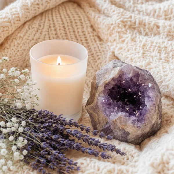 A candle and amethyst crystal with lavender